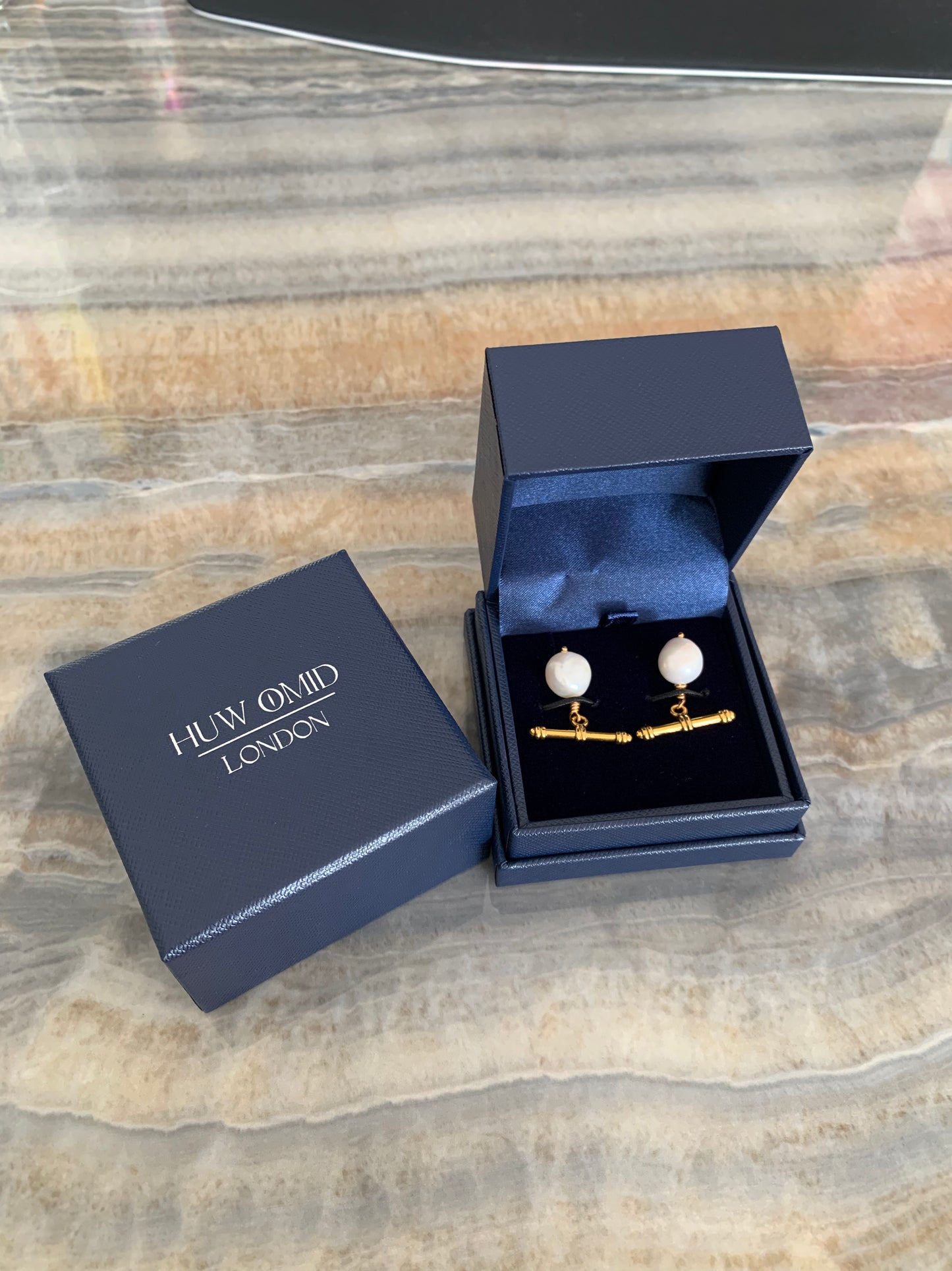 Close up of white baroque pearl cufflinks, cuff links with gold toggles