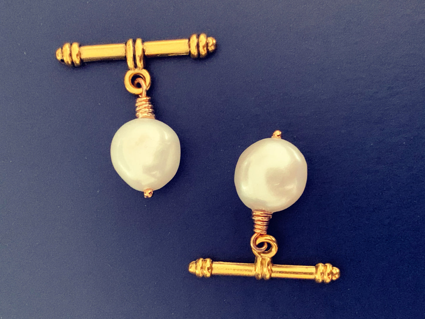 Close up of white baroque pearl cufflinks, cuff links with gold toggles