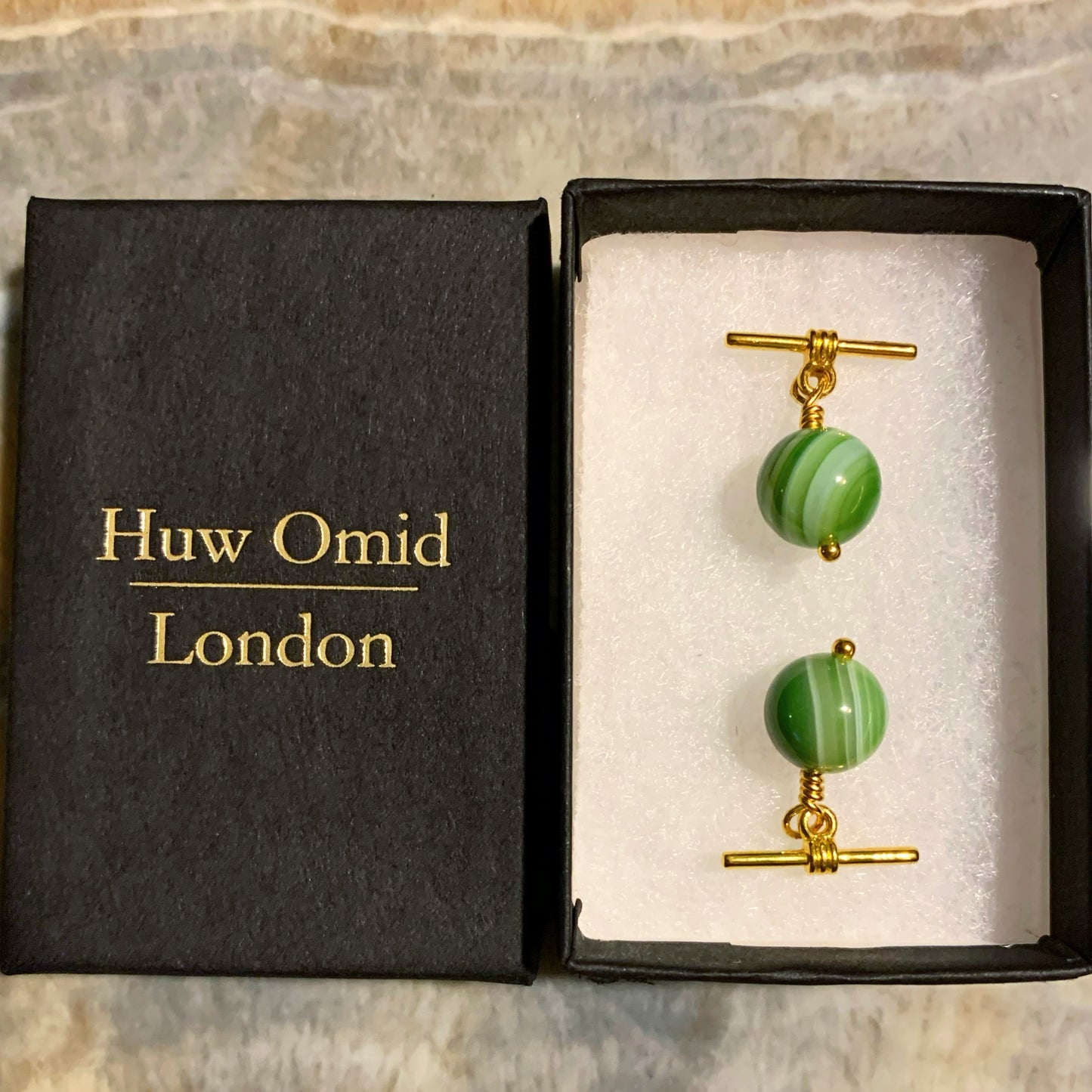 Close up of green banded agate cufflinks, cuff links with gold toggles